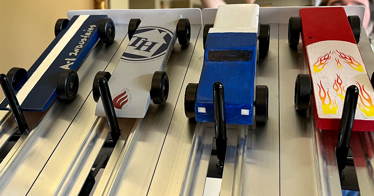 Pinewood Derby cars at start line